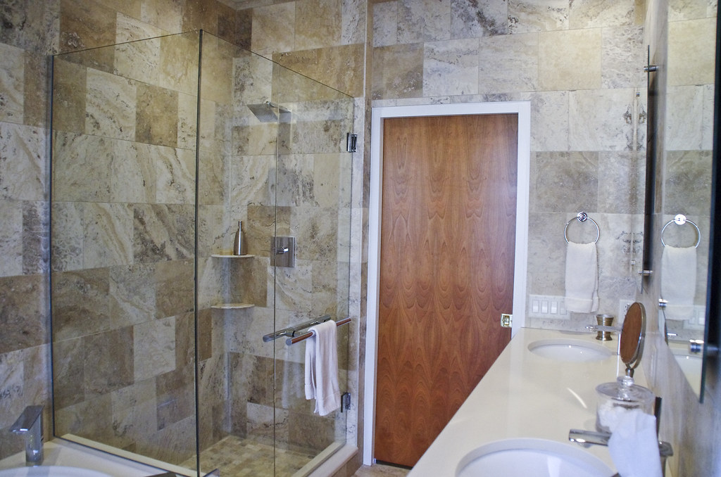 Modernes Badezimmer mit Dusche, Waschbecken und Natursteinfliesen